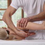 Woman having chiropractic back adjustment. Osteopathy, Alternative medicine, pain relief concept. Physiotherapy, sport injury rehabilitation
